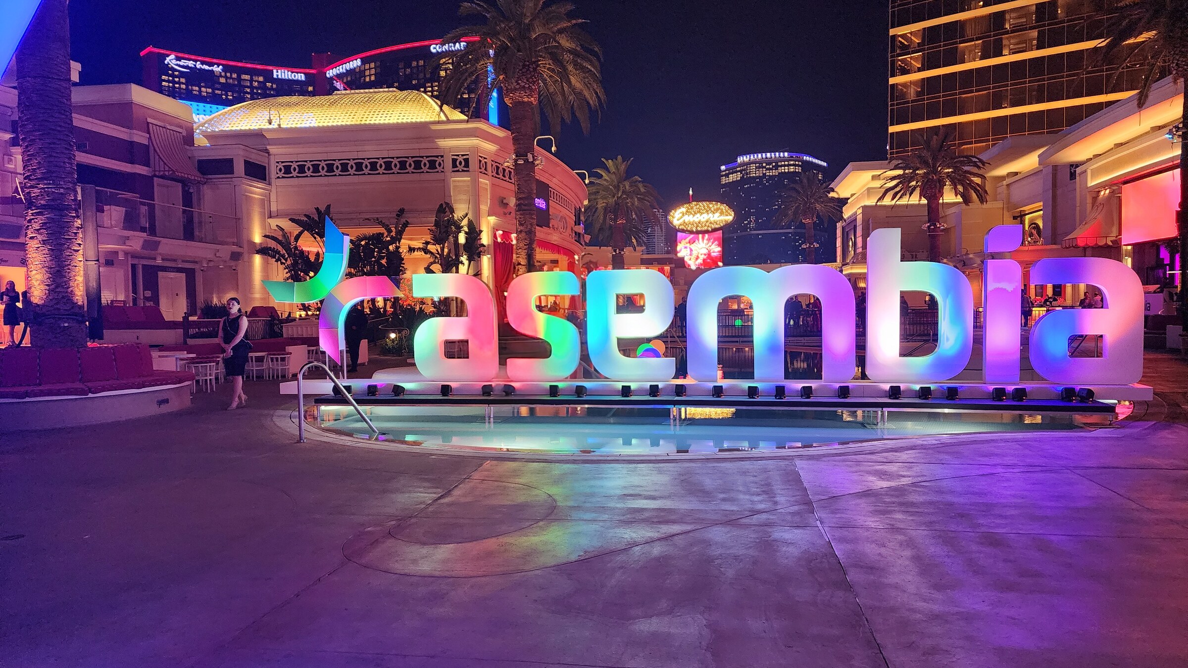 Wide conference environment featuring illuminated Asembia branding and scenic lighting