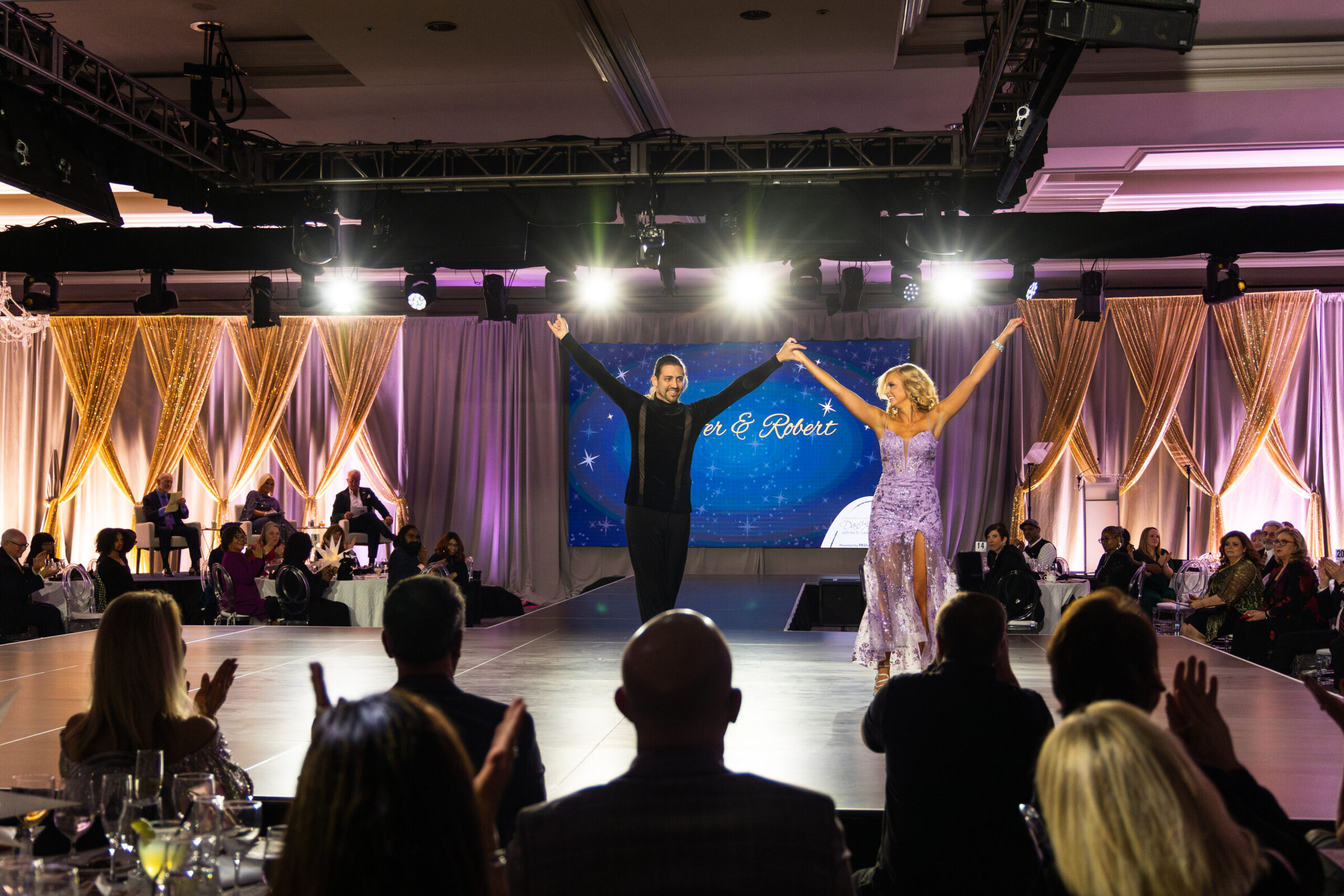 Wide ballroom view of Dancing with the St. Louis Stars showing the stage, dance floor, and audience