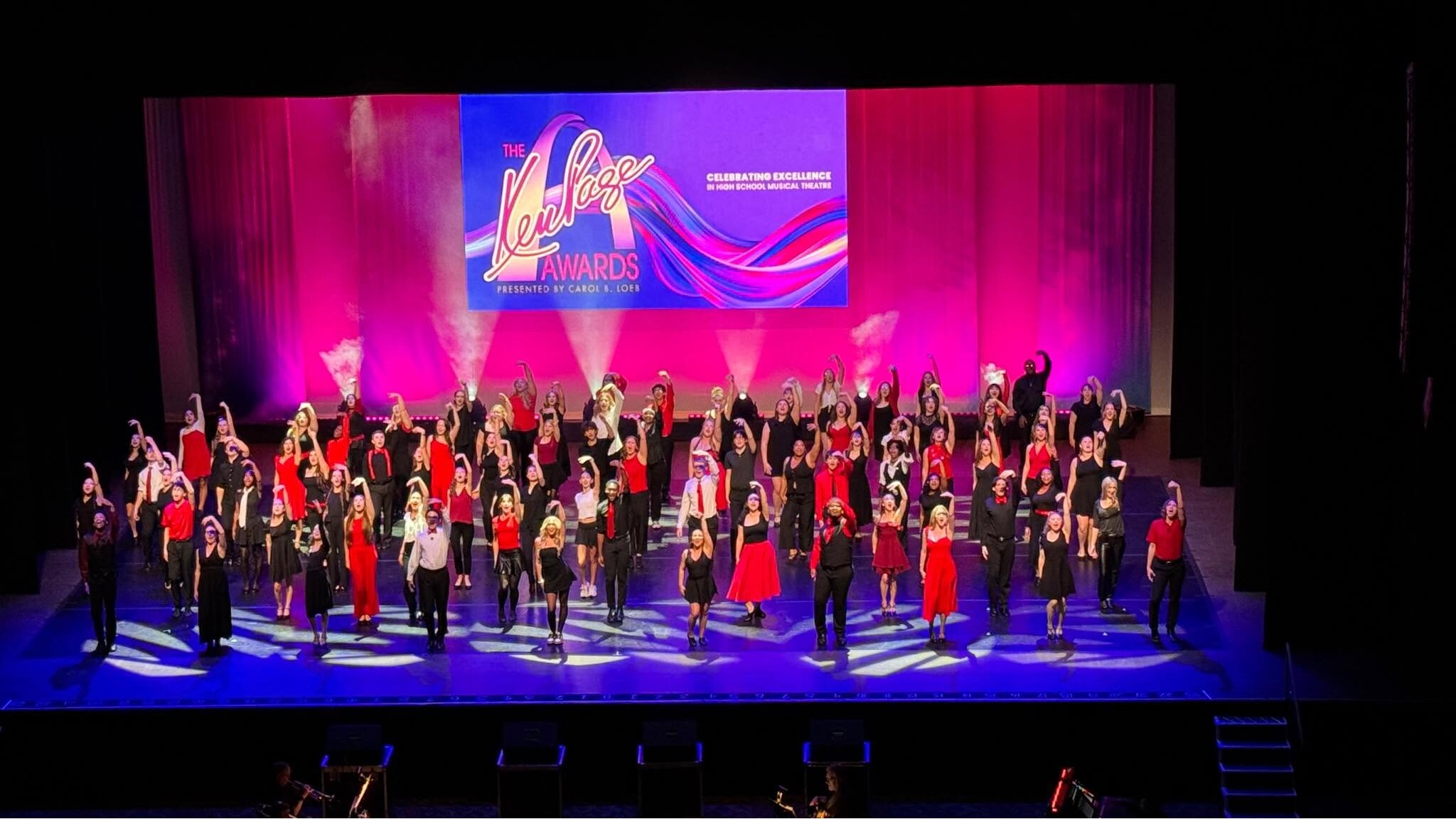 Full-stage view of the Ken Page High School Musical Awards with the student ensemble, LED screen, scenic backdrop, and theatrical lighting