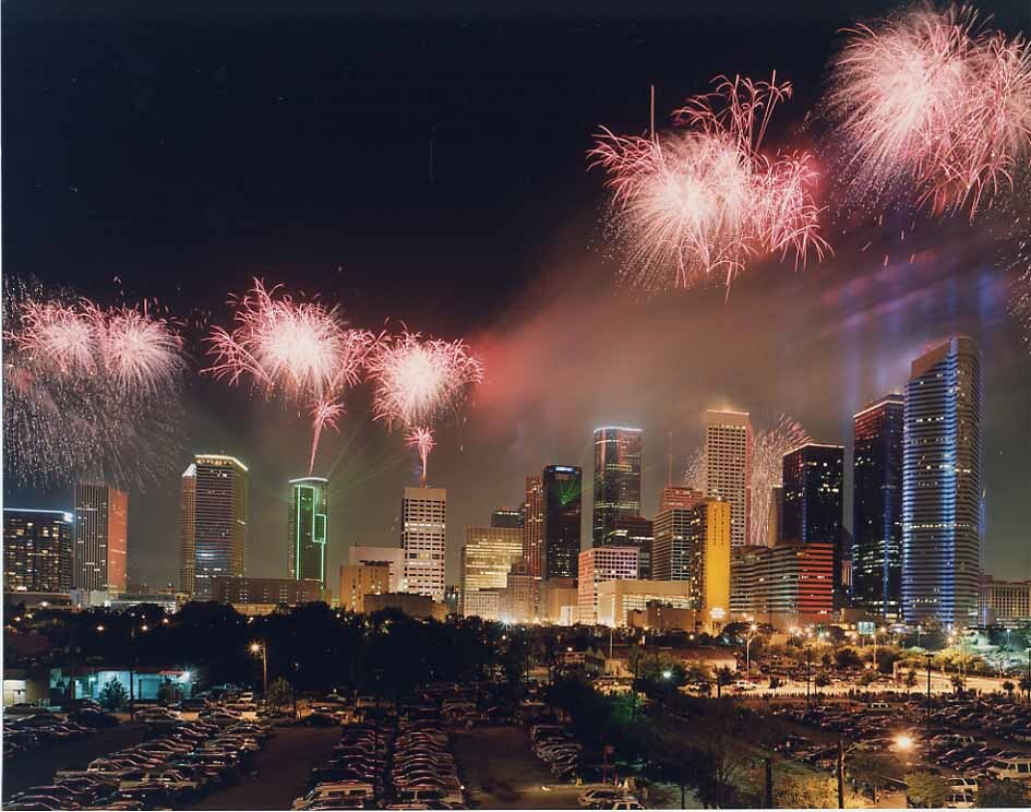 Wide nighttime view of The Power of Houston event with the city skyline, audience, and fireworks