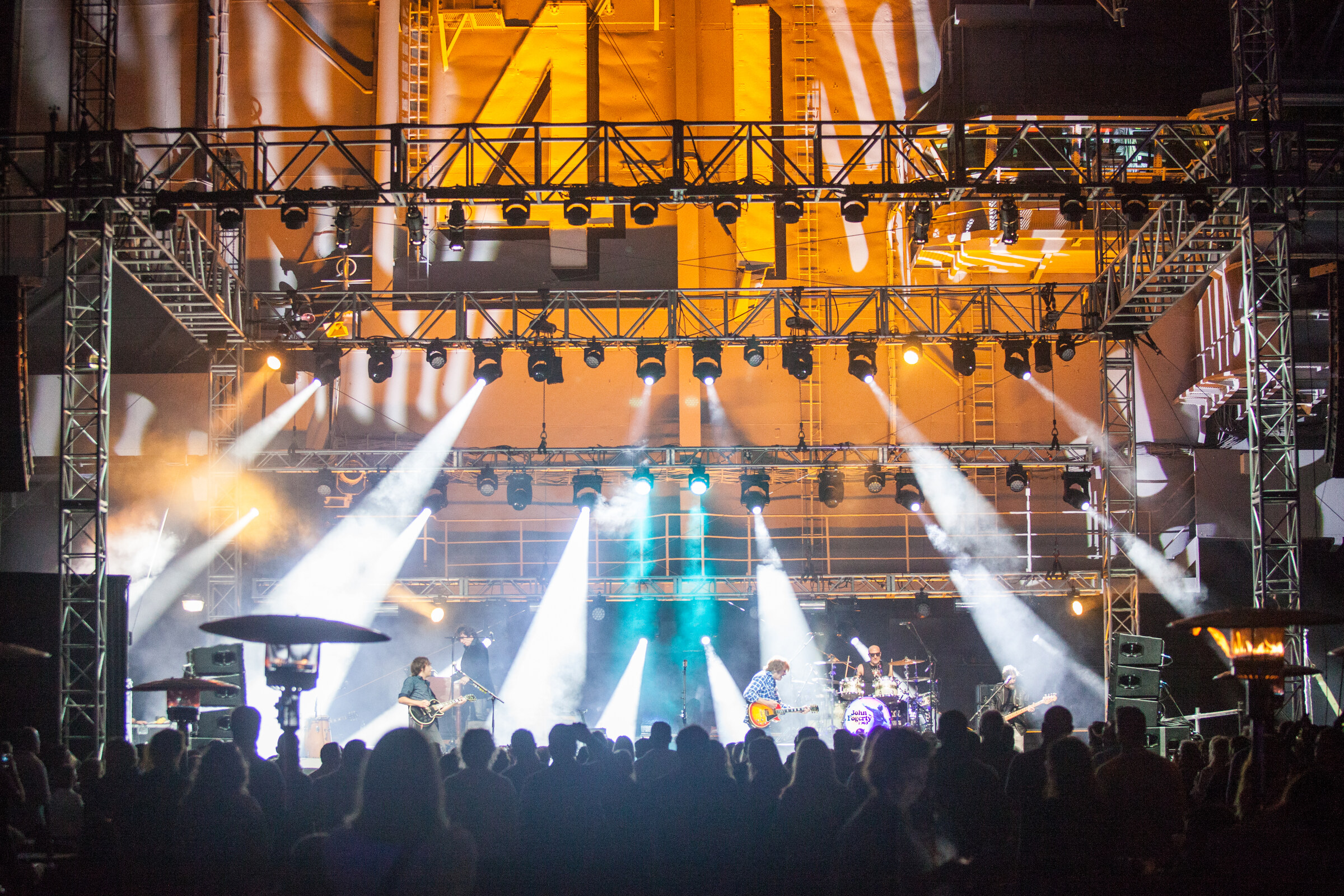 Wide stage view of the John Fogerty concert aboard the USS Midway with concert lighting and audience